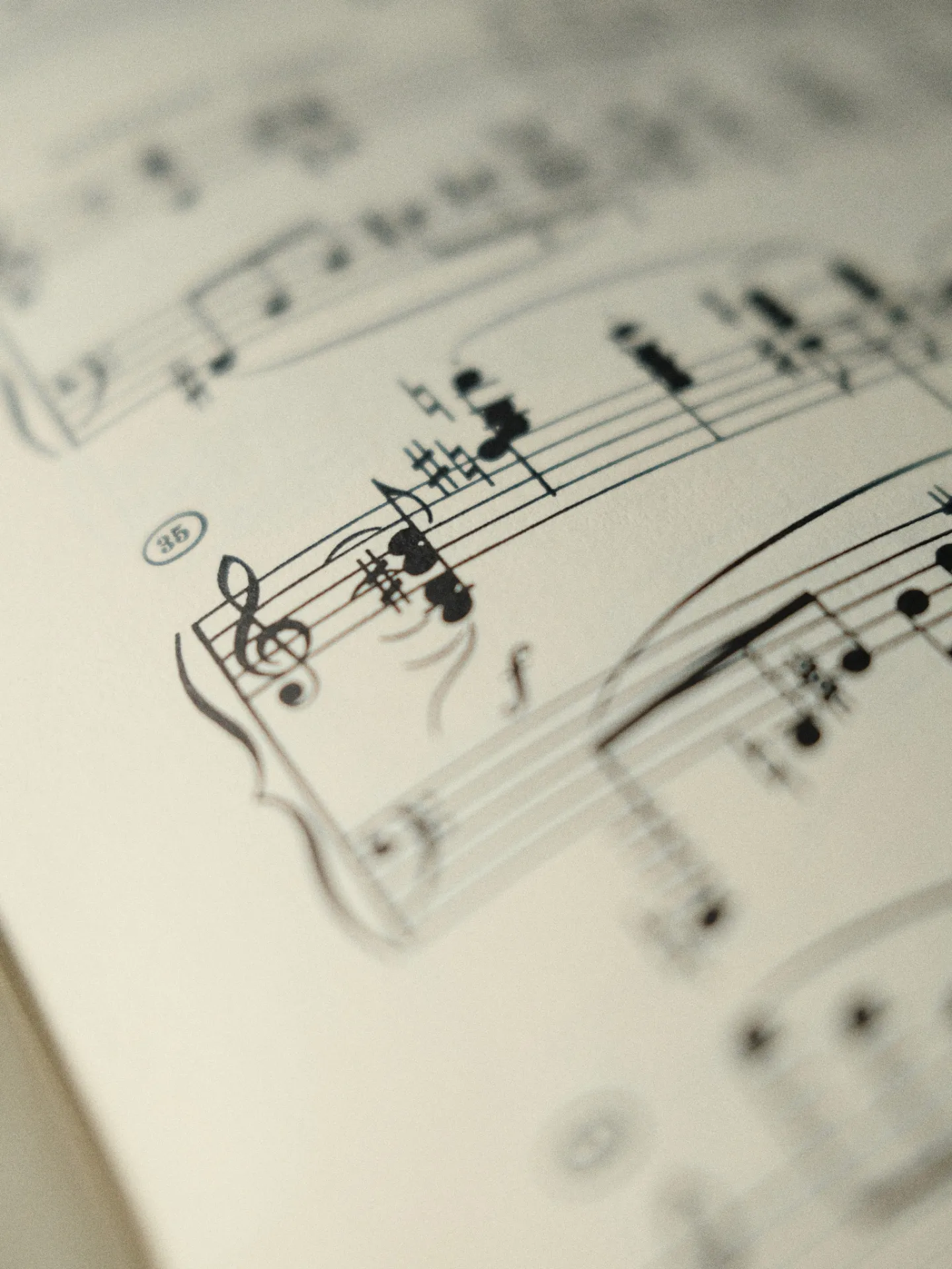 Sheet music close-up showing a treble clef and notation, slightly out of focus.